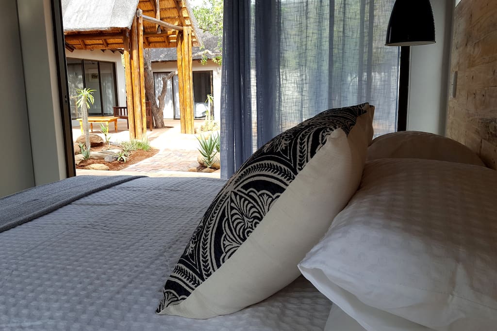 The room has large sliding doors that open onto a central courtyard and pool deck.
