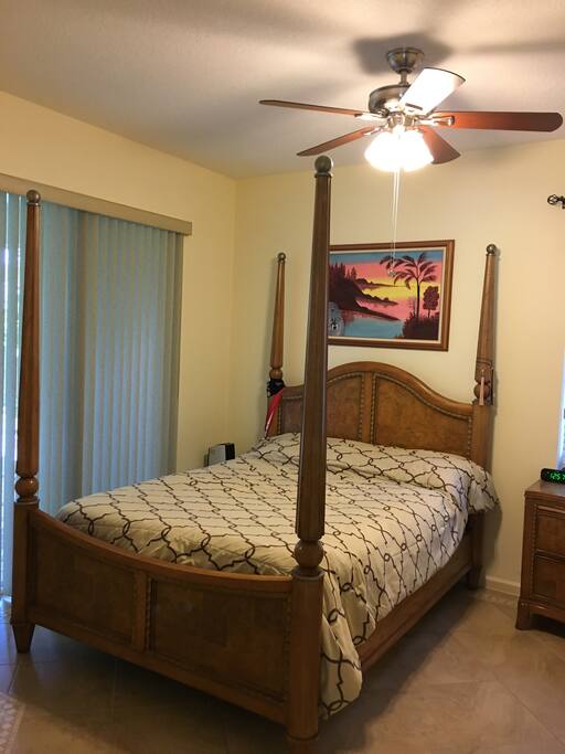 Room available for guest(s) including queen size bed, fan, night table, closet, windows and great view of patio.
