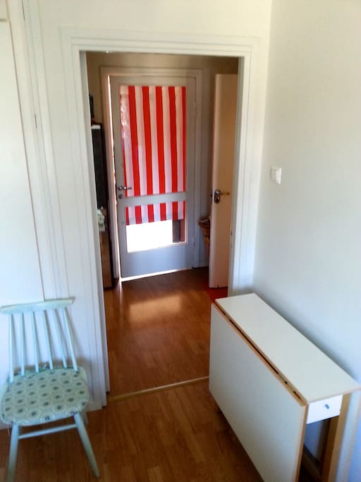 The view from the bedroom to the rest of the apartment. Our private room is behind the striped door, and on the right are the toilet and kitchen.