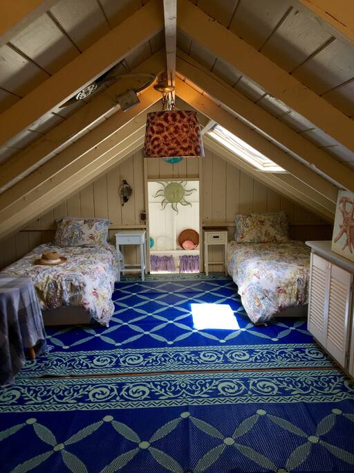 Sleeping loft with 4 twin beds and skylight.