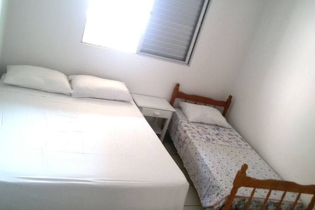 Quarto de casal com 1 cama de solteiro extra. Olhando da porta