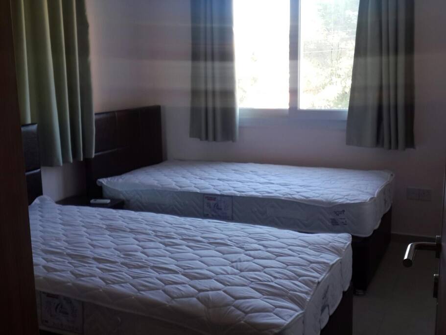 1st bedroom with two beds, wardrobe, air cooling system and two bedside tables