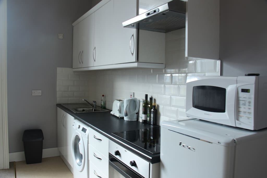 The kitchen is equipped with a microwave, stove, oven, and a kettle.