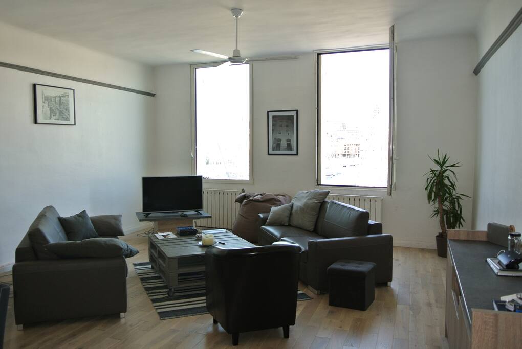 Le salon avec les 2 grandes fenêtres avec vue sur le vieux port .