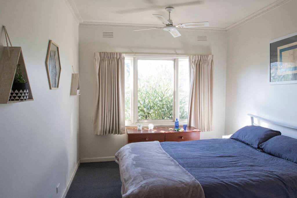 The main bedroom gets plenty of natural light and the bush gives great privacy from the street. (Red flowers late Summer)