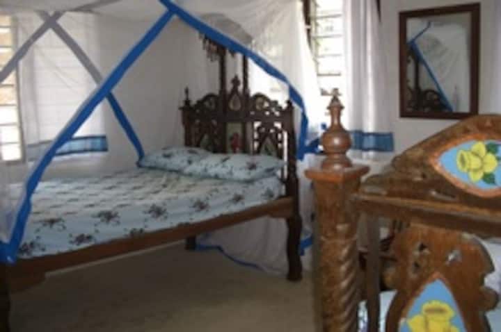 Një nga dhomat e gjumit ka dy krevate tradicionale swahili të dekoruara me xham të lyer. Ato nuk janë aq të gjera sa krevatet dopio modernë.