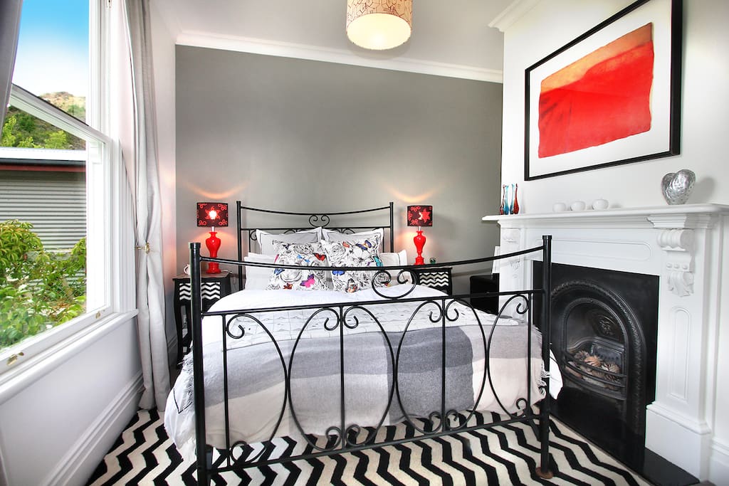 Bedroom three features a wrought iron queen bed and decorative fireplace.