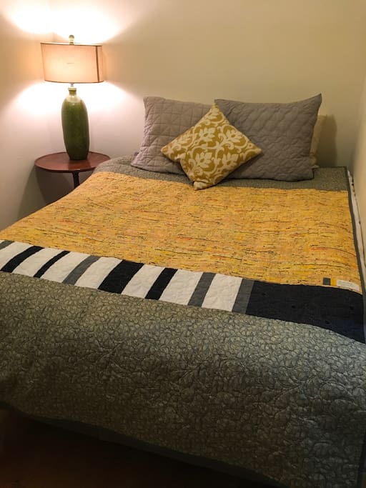 Queen size bed with home-made quilt. Bedroom is a separate room with bed & desk.