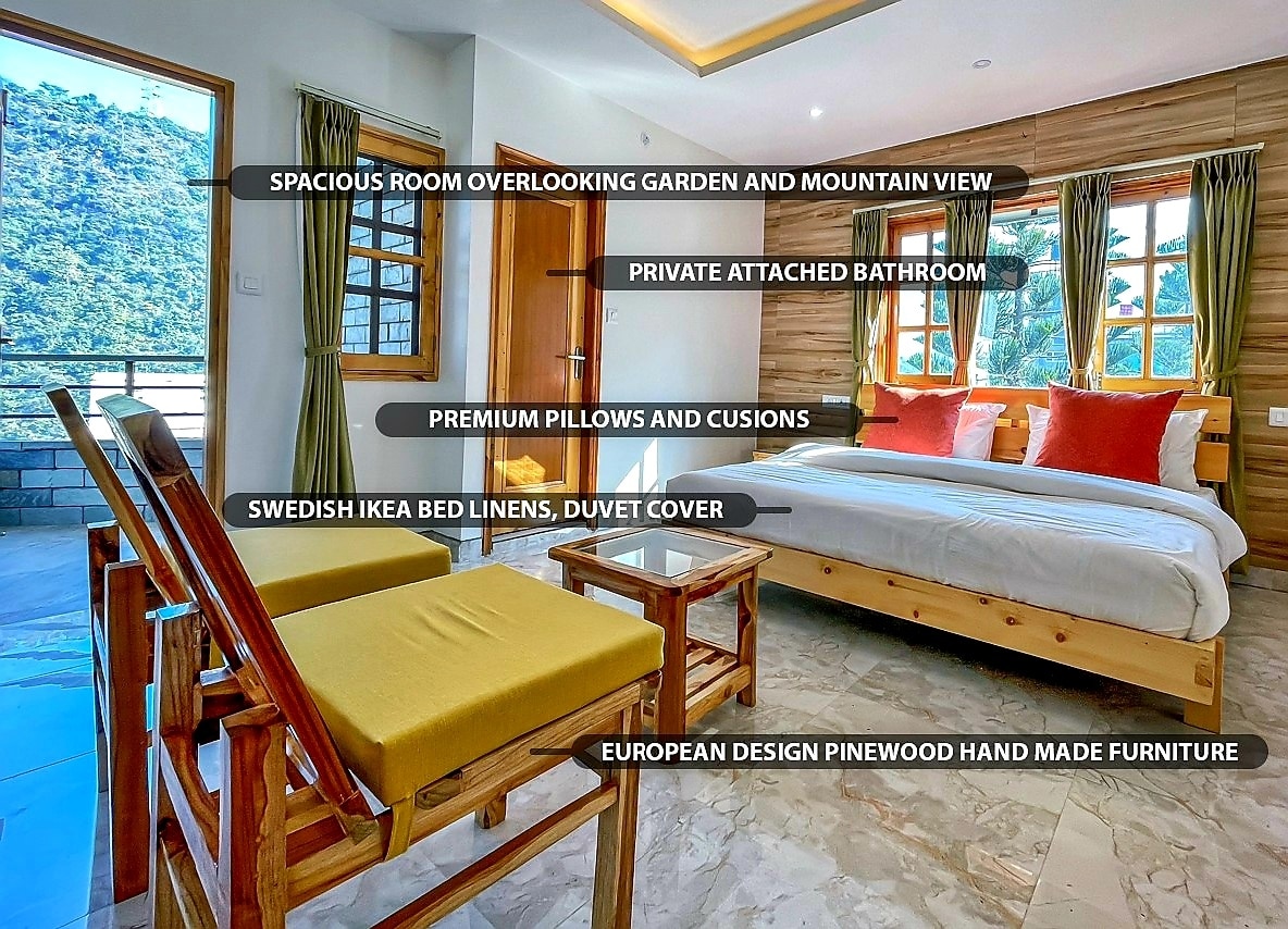 A spacious room features a large bed adorned with Swedish IKEA bed linens and a duvet cover. Handmade pine wood furniture is included, along with premium pillows and cushions. Large windows showcase views of the garden and mountains, while an attached bathroom provides added convenience.