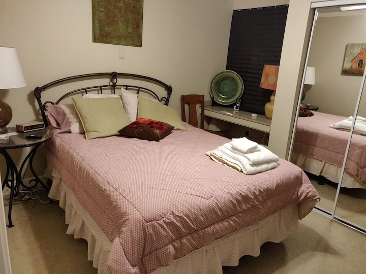 Segundo dormitorio con cama tamaño queen y televisión por cable.