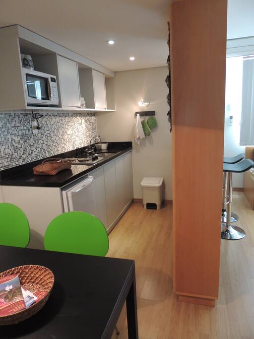 MESA DE JANTAR E COZINHA EM SEGUNDO PLANO