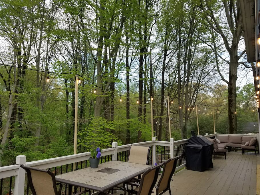 Lighted deck with dining table, grill and lounge.