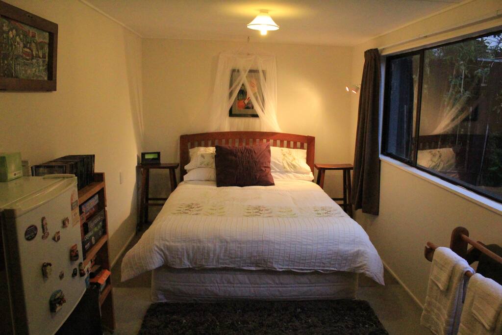 Comfortable Queen bed with large window with view of garden.