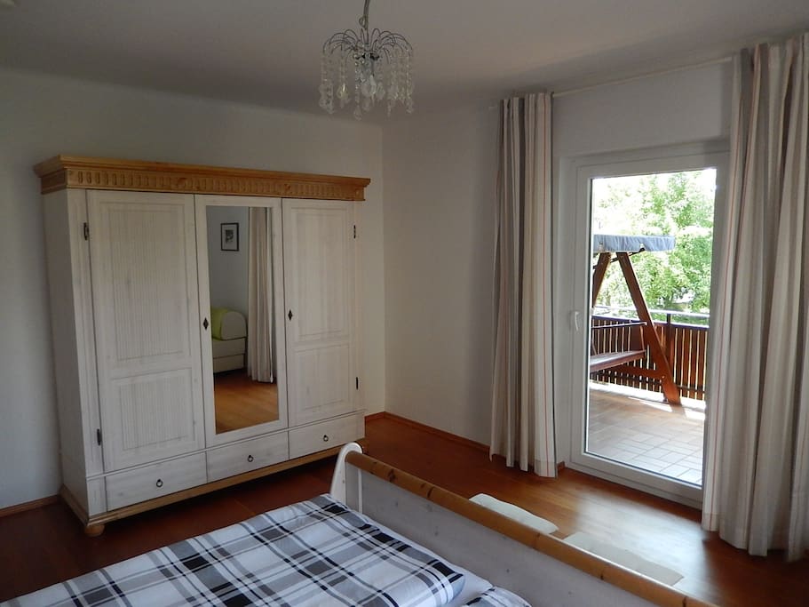 Schlafzimmer mit Kleiderschrank und Balkon