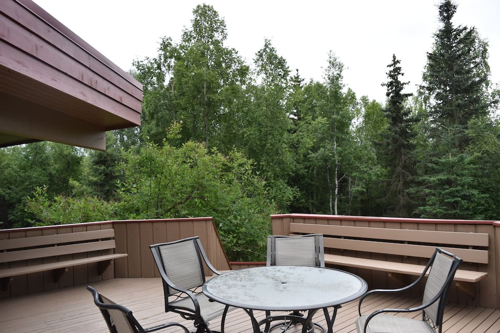Open-air deck during the summer, overlooking the forested grounds