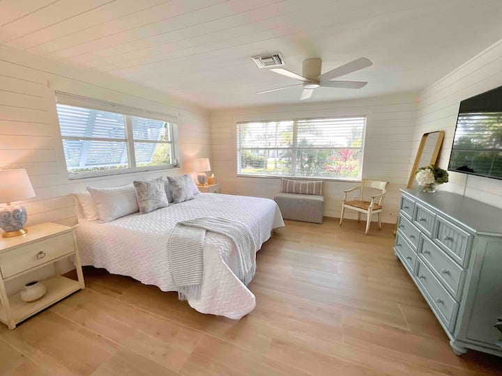 Dormitorio principal lleno de sol con baño privado.  El baño principal tiene un suelo de mármol y ducha, camina en la ducha y dos tocadores con acceso al armario principal y al dormitorio principal.