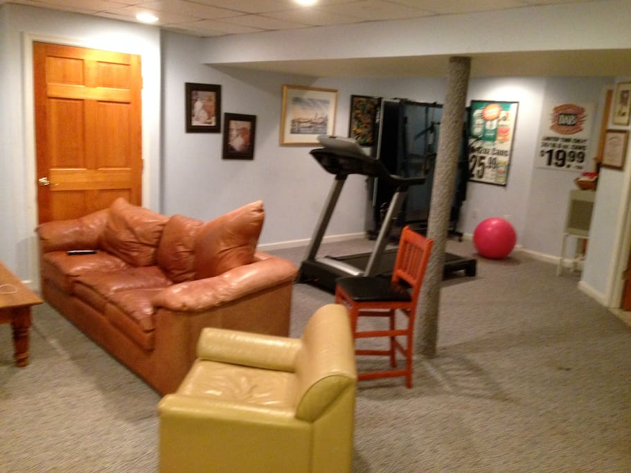 another tv, treadmill, leather couch and chair