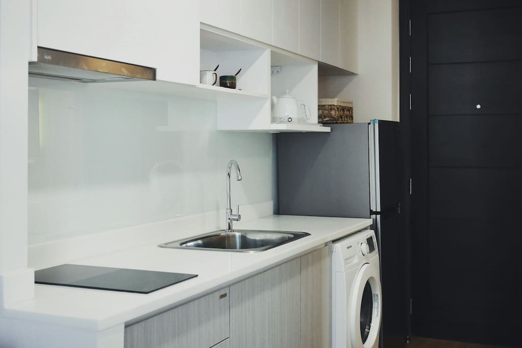 kitchen with electric cooker, washing machine and refrigerator.