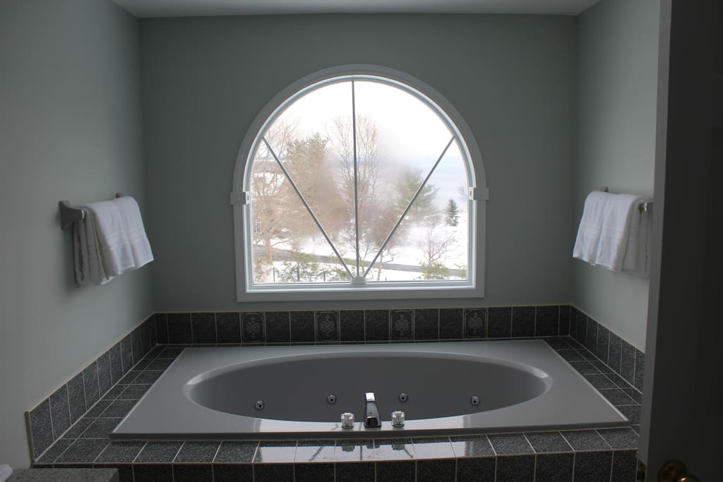 Upstairs master bathroom has a jacuzzi tub overlooking the lake