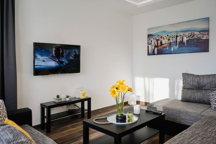 Acogedora sala de estar con un televisor inteligente plano.