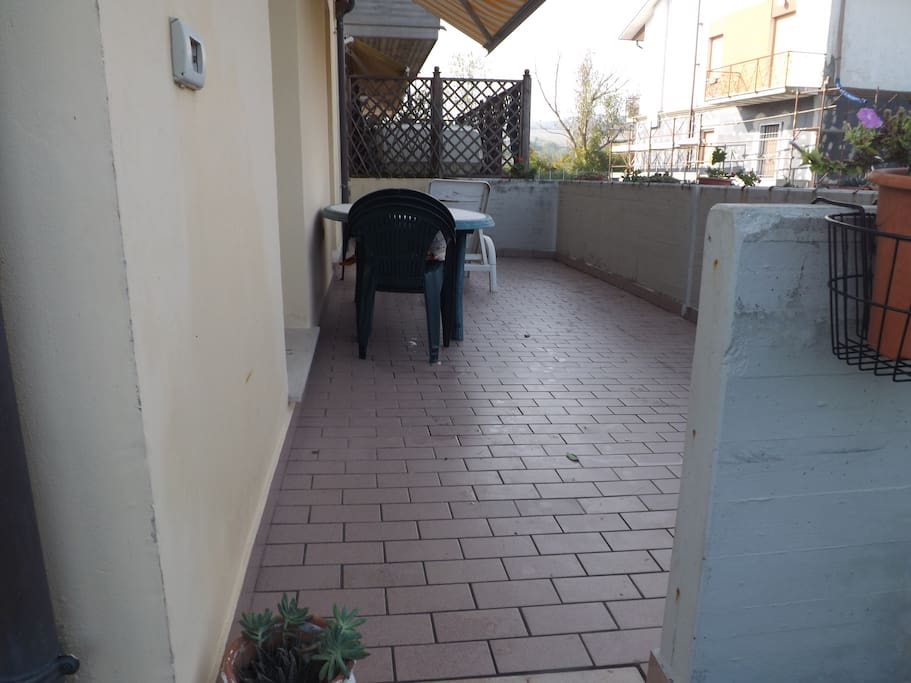 La terrazza accessibile dalla porta finestra della cucina e della stanza da letto principale e che scende al giardino e al parking