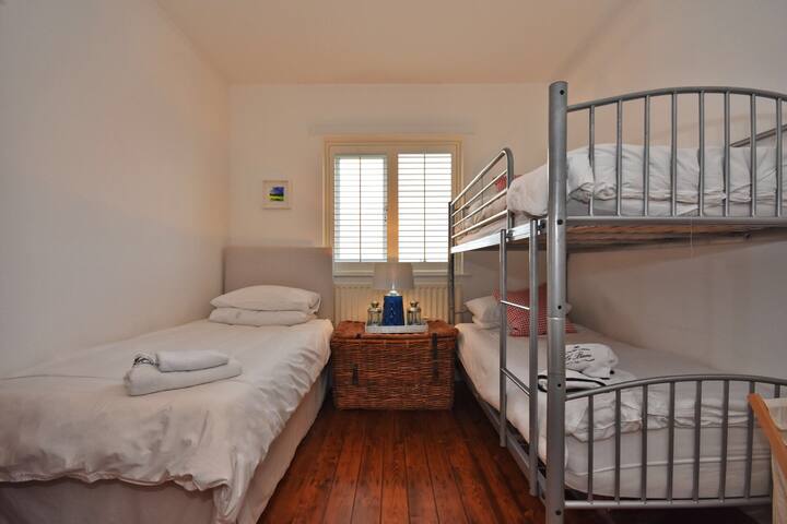 Dormitorio grande con literas y cama individual con vistas a los campos.  Lavabo y armario empotrados.