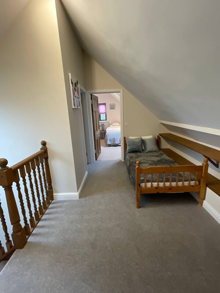 Il letto singolo di riserva nel grande corridoio al piano di sopra. 
È un letto per adulti di dimensioni standard, quindi può essere utilizzato per adulti o bambini. È di fronte al bagno e tra le due camere da letto, ma è privato quando le porte della camera da letto sono chiuse. 