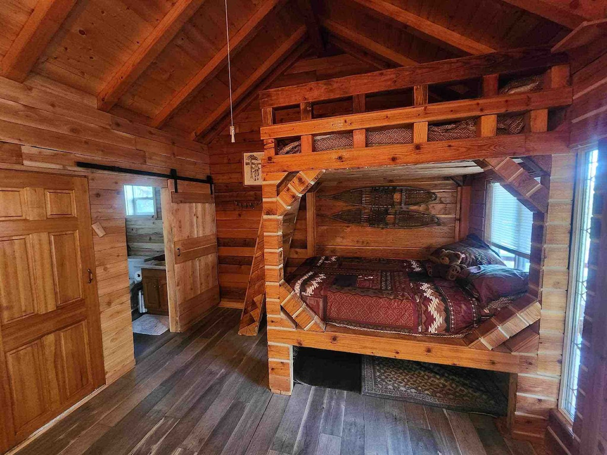 Literas de colchón completas en el camino de entrada principal de la cabaña. Hay un baño completo más allá de la puerta corrediza con barbacoa.