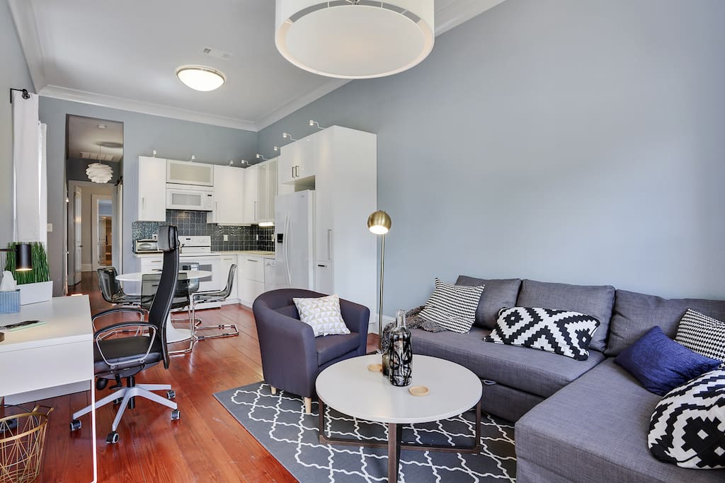 View of the living room and eat-in kitchen as you come in the front door. Our motto is as many pillows as possible! Comfy couch also transforms into a full bed for extra sleeping space. Eleven foot ceilings keep it cool and spacious.
