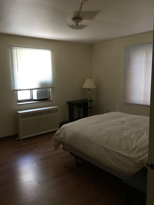 Bedroom with queen bed and desk.