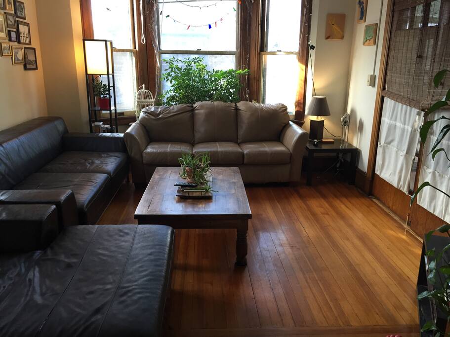 Large, sunny living room with 2 couches and a large flat screen TV