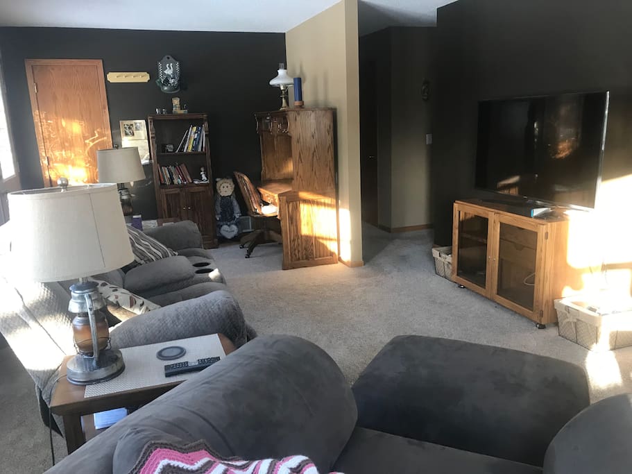 Living space with large TV and desk space.