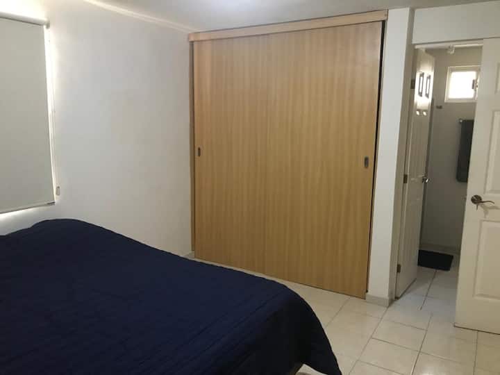 غرفة نوم رئيسية مع خزانة وتلفزيون وحمام كامل