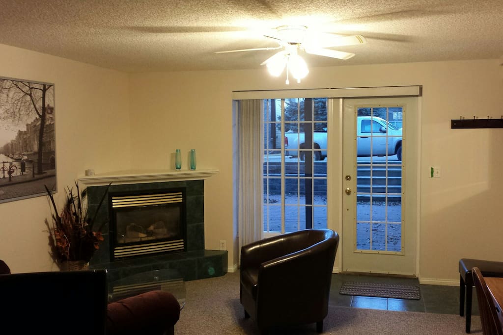 Living area with gas heating fire place, showing south facing sunken courtyard and entry door to suite.