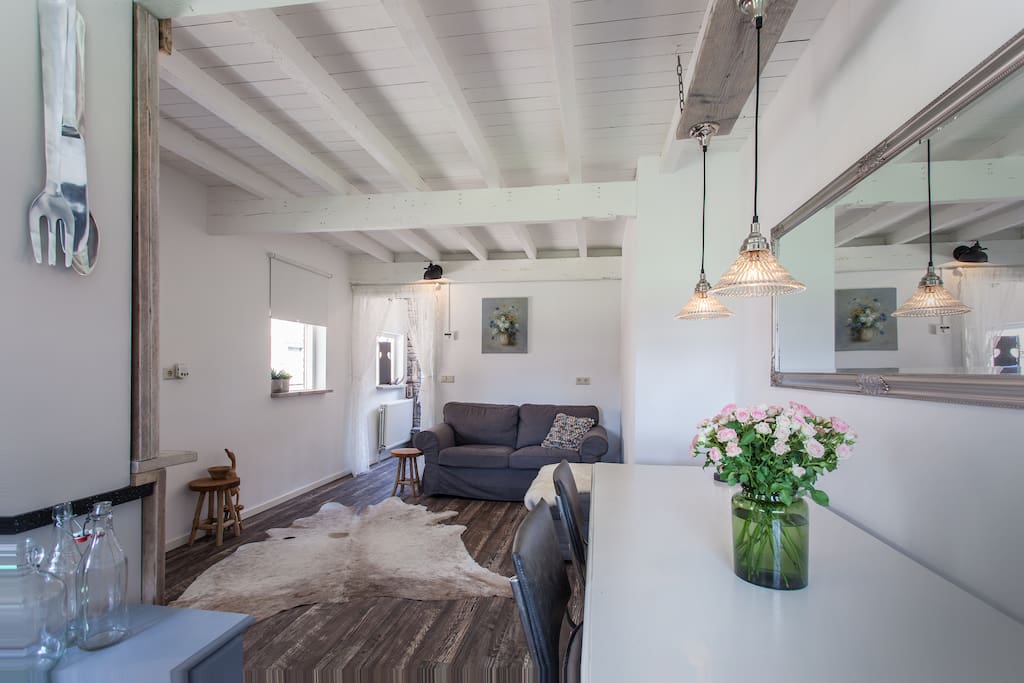 De gezellige woonkamer met traditionele houten balken van de oude stal