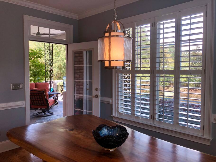 View from kitchen table to large back porch and yard