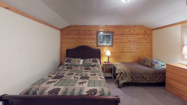 La chambre 1 est située à l'extérieur de la cuisine à l'étage principal. Peut accueillir confortablement 3 personnes avec 1 lit Queen et 1 lit double. Équipé d'une télévision à écran plat.