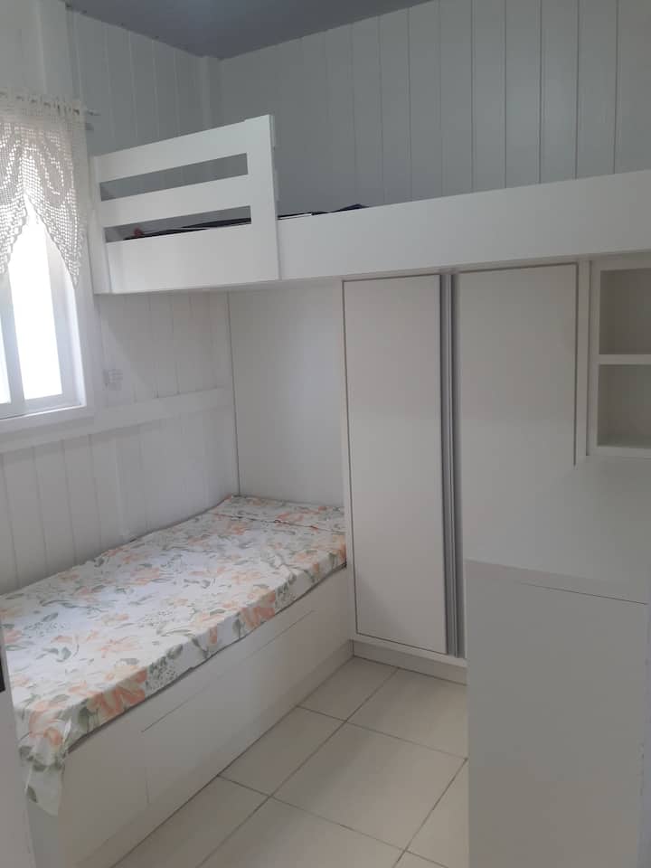 חדר שינה יחיד עם שתי מיטות קומתיים מתוכננות וגם ריהוט מתוכנן.