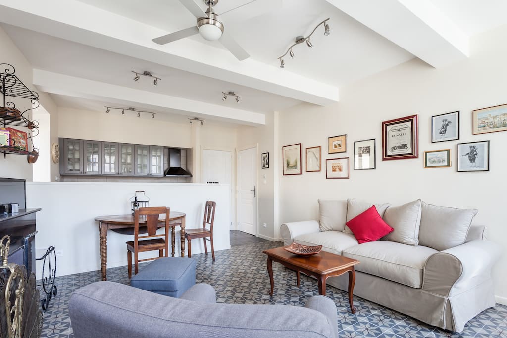 Open plan living room, with dining area and kitchen in the background