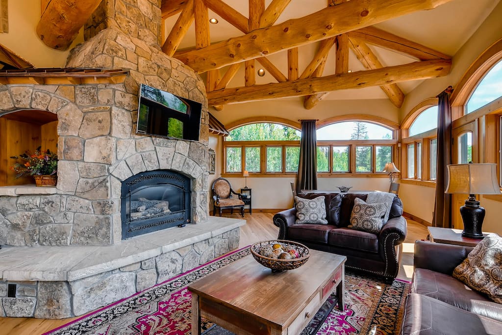 with gas fireplace, TV and door leading out to deck with hot tub