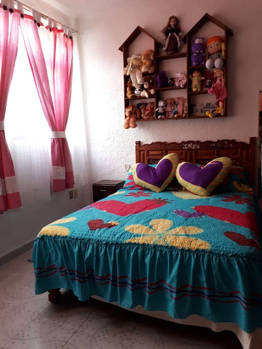 Cama matrimonial con ropa de cama y almohadas para dos personas.