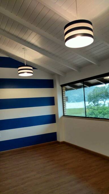Quarto 2 no andar superior. Linda vista para o mar. Acomoda 5 pessoas, sendo uma bicama com cama auxiliar e um beliche (cama de casal embaixo e solteiro em cima). Móveis novos recém adquiridos. Piso vinílico, proporcionando conforto térmico e fácil manutenção de limpeza. Ar condicionado split.