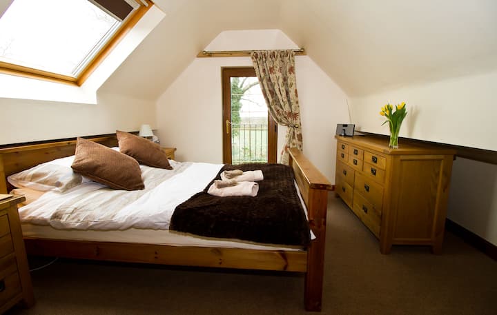 Ზემოთ საძინებელი საკუთარი ტელევიზორით, აივნით, რომელიც მალვერნ-ჰილზს უყურებს.