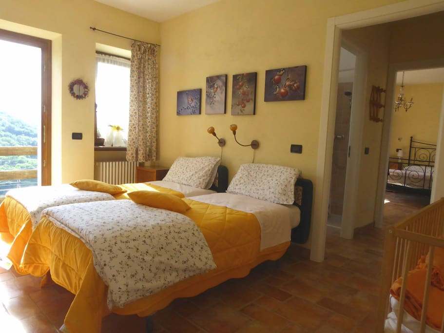 Room with two single beds, connected with the double bed bedroom. / Camera doppia con letti singoli, comunicante con camera matrimoniale.