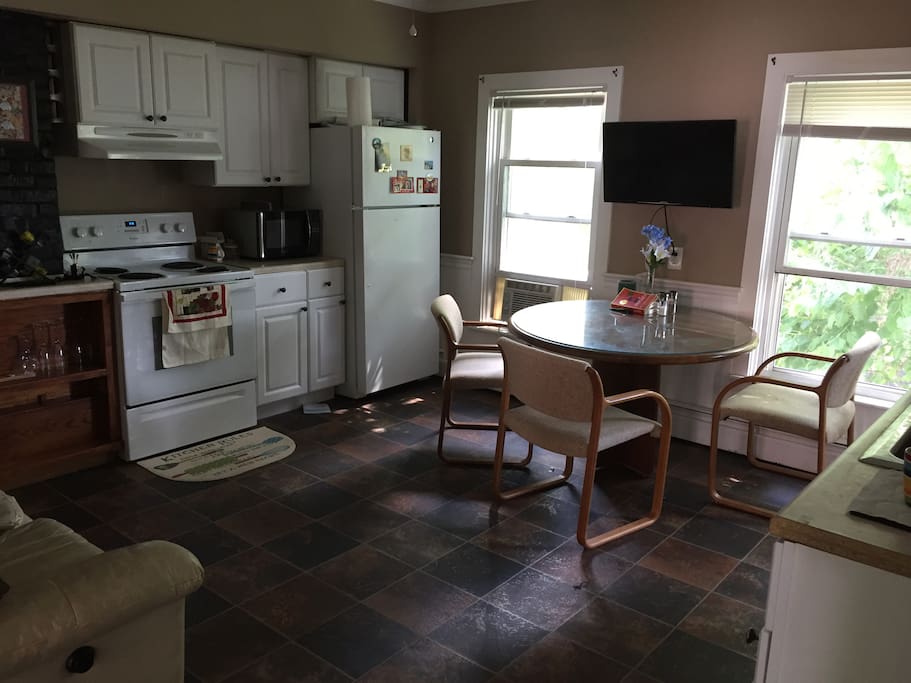 Kitchen with Leather recliner love seat and TV with netflix