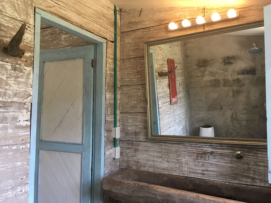 One of two bathrooms. Both with with natural light and ventilation. Wooden handwash, theatre light.