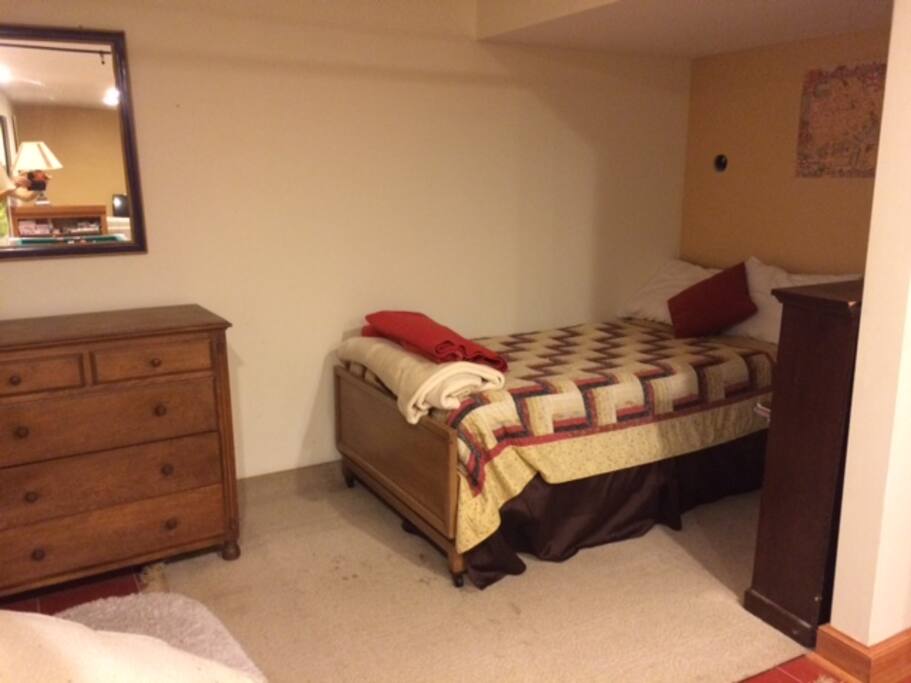 At the opposite end of the apartment is a sleeping alcove with a full size bed (shown above). The bed alcove is out of view of the rest of the apartment, since its tucke around a corner, but it is not technically a separate room, with a wall and door entry etc. It is plenty private and has floor to ceiling drapes that provide a greater sense of privacy from the rest of the space and it feels plenty private, but it is not walled off as a distinct bedroom.
In addition to tbe sleeping alcove, there is a single sleeping nook in the common area of the apartment,which is fitted with an upholstered pad, and which kids and teens seem to enjoy for sleep or as a reading area.