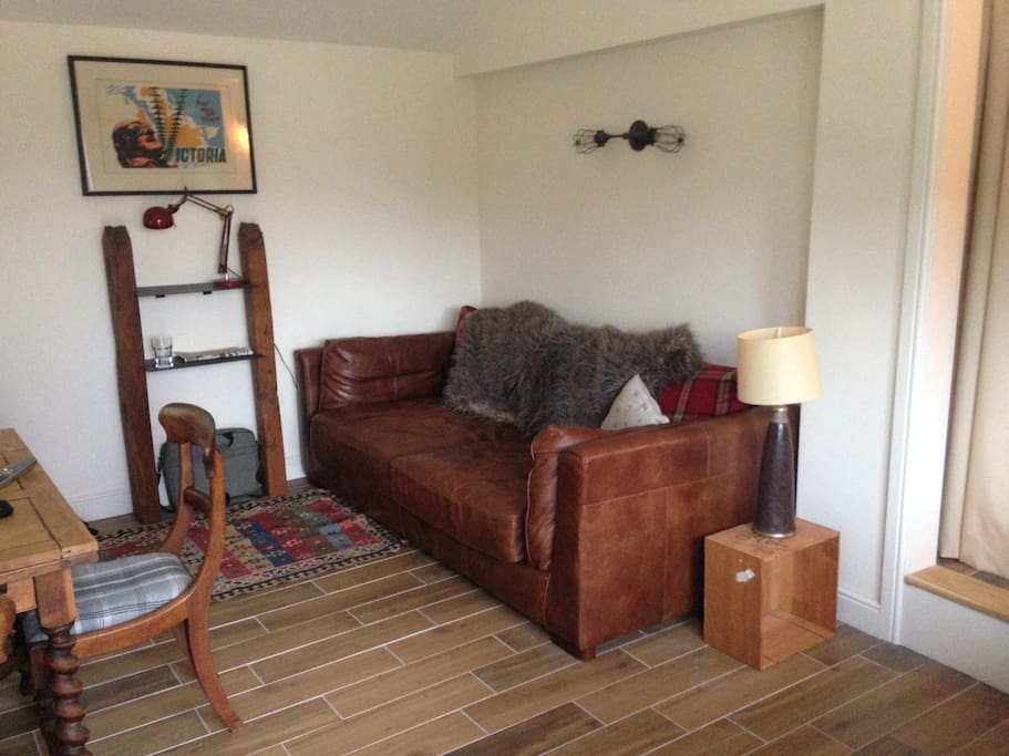 Living area, with large sofa, eating area and kitchen facilities