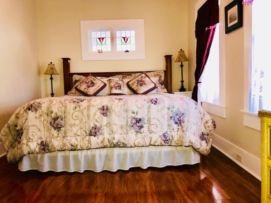 Super comfortable king size bed! Notice original stained glass window over the bed!