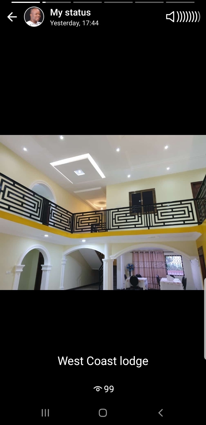 An expansive interior space is highlighted by high ceilings and modern architectural details. A sleek balcony railing provides an open view to the floor below, while warm lighting enhances the welcoming atmosphere. Arched doorways and neutral wall colors contribute to a bright, airy environment.